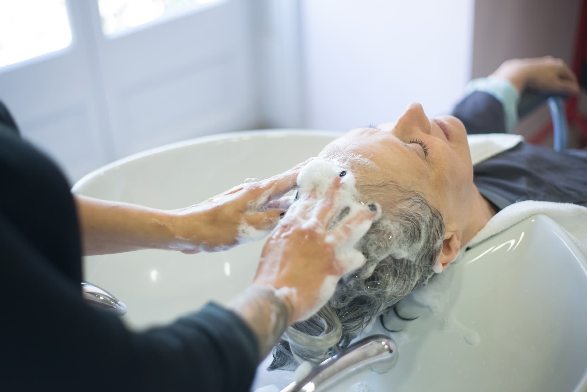 Haren die worden gewassen in een kappersstoel voor een goede haarverzorging